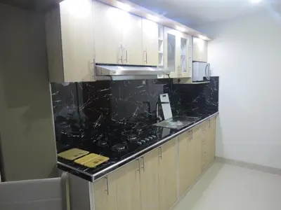a kitchen with white cabinets and black counter tops at DEPARTAMENTO-Hospedaje EL RINCONCITO II 100m2, 3hab, 4baños, sala, comedor, cocina in Jauja