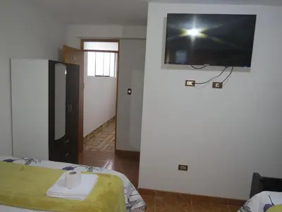 a room with a flat screen tv on the wall at DEPARTAMENTO-Hospedaje EL RINCONCITO II 100m2, 3hab, 4baños, sala, comedor, cocina in Jauja
