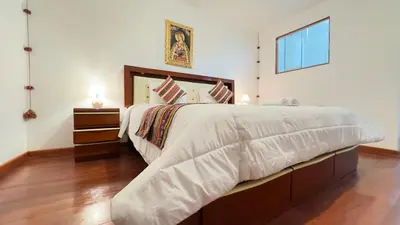 a large bedroom with a large bed with white sheets at Casona Libertrek Inn in Cusco