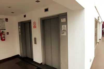 a row of elevator doors in a building at Excellent apartment, access to pool, grills, ballroom in Lima