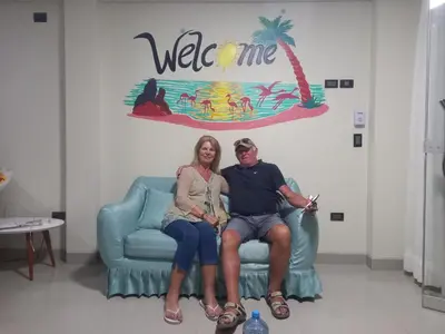 a man and a woman sitting on a chair in a room at Hotel Sunlight in Paracas