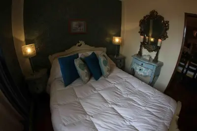 a bedroom with a white bed with blue pillows at Bamba House Cusco in Cusco
