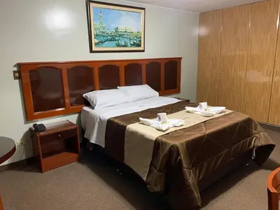 a hotel room with a large bed with two plates on it at Grand Hotel Betsy in Lima