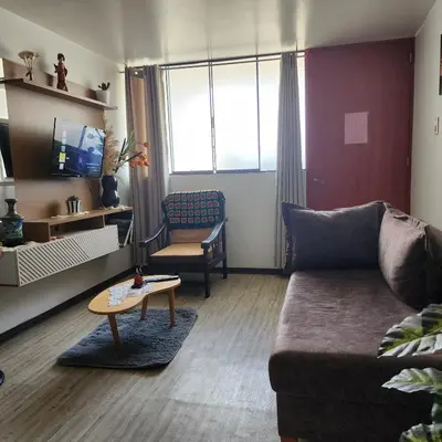a living room with a couch and a table at Acogedor APT a 20 min Aeropuerto in Lima