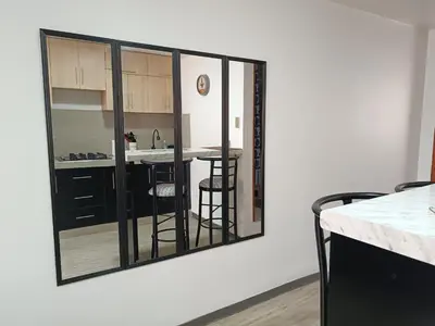 a mirror hanging on a wall in a kitchen at Acogedor APT a 20 min Aeropuerto in Lima