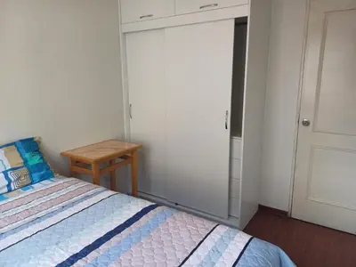 a bedroom with a bed and a closet with a door at Habitación acogedora Orué in Lima