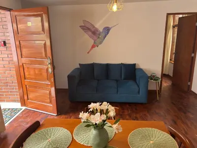 a living room with a blue couch and a bird on the wall at San Miguel, lindo depa, 3 camas, internet y cable in Lima