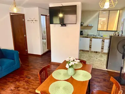 a living room with a table with a vase of flowers on it at San Miguel, lindo depa, 3 camas, internet y cable in Lima
