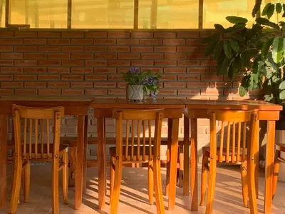 a wooden table with two chairs and a table with a plant at San Miguel, lindo depa, 3 camas, internet y cable in Lima