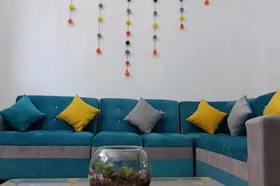 a blue couch with pillows and a vase on a table at Qori Garden Apartment in Cusco