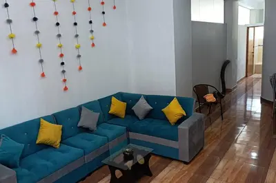 a living room with a blue couch with yellow pillows at Qori Garden Apartment in Cusco