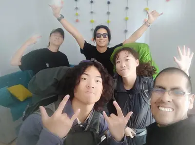 a group of people sitting on a couch with their hands up at Qori Garden Apartment in Cusco
