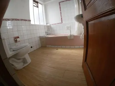 a bathroom with a pink tub and a toilet at Departamento en el centro histórico del Cusco in Cusco