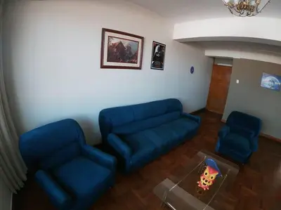 a living room with a blue couch and a table at Departamento en el centro histórico del Cusco in Cusco