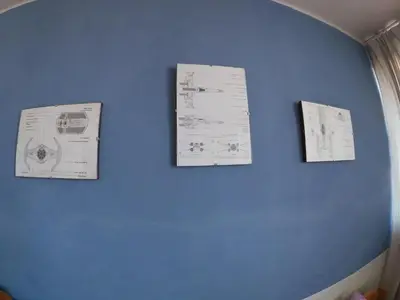 three pieces of paper hanging on a blue wall at Departamento en el centro histórico del Cusco in Cusco