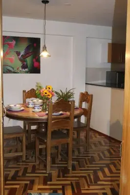 a dining room with a table with chairs and flowers at El colibrí de San Blas in Cusco