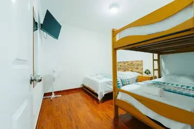 a bedroom with two bunk beds and wooden floors at ALOJAMIENTO ISLA BLANCA in Paracas