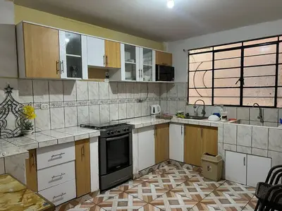 a kitchen with wooden cabinets and a black oven at Espacio para ti y tu familia in Lima