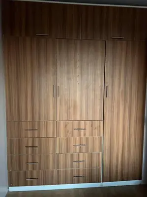 a large wooden closet with four wooden drawers at Espacio para ti y tu familia in Lima