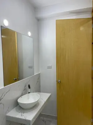 a bathroom with a sink and a wooden door at Hurin Hotel in Ica