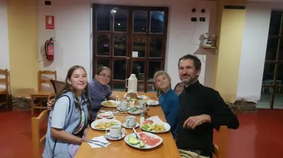 a group of people sitting at a table eating food at CasaNostra Choquequirao in Cachora