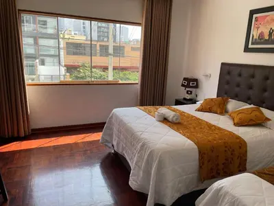 a bedroom with two beds and a large window at Lima HOUSE MILANI in Lima