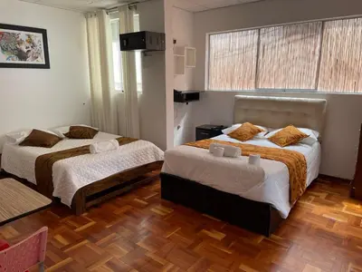 a bedroom with two beds and a window at Lima HOUSE MILANI in Lima