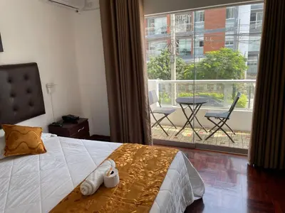 a bedroom with a bed and a view of a balcony at Lima HOUSE MILANI in Lima