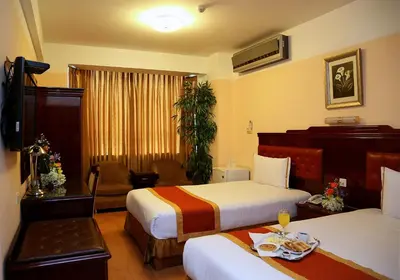 a hotel room with two beds and a couch and a table at Hotel Princesa in Lima
