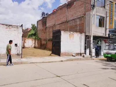 a man walking down a street next to a building at Hospedaje TOSCANO SUITES in Huancayo