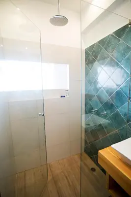 a shower with a glass door in a bathroom at Kauhuhu Casa Hotel in San Bartolo