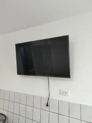 a flat screen tv hanging on a wall at Sanbar House in San Bartolo