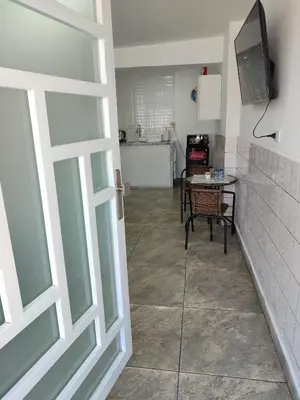 a door leading to a kitchen with a table and a table at Sanbar House in San Bartolo