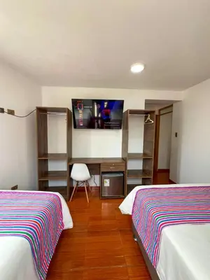 a hotel room with two beds and a tv at Golden Paris Hotel 