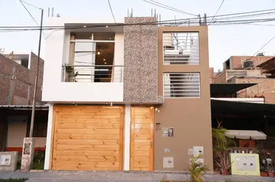 a house with a wooden garage door at Hermosa Habitación c/ Baño privado - Huacachina. in Ica