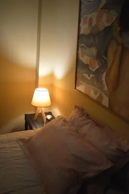a bedroom with a bed with a lamp and a painting at Lima Guest Room House in Lima