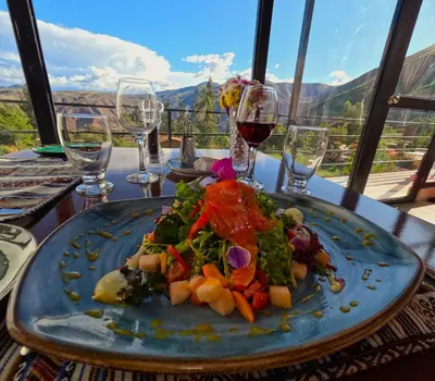 a plate of food on a table with wine glasses at MISKI SAMAY DOMO BOUTIQUE in Urubamba