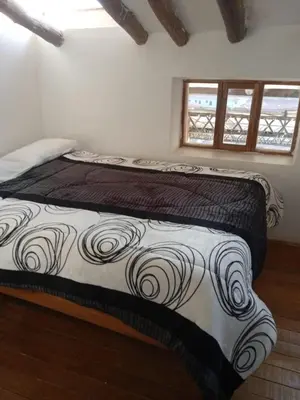 a bed with a black and white comforter in a room at Casa Cusco guest house in Cusco