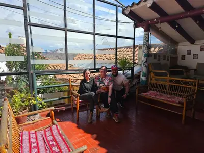 three people sitting in a room with a view of the desert at Casa Cusco guest house in Cusco