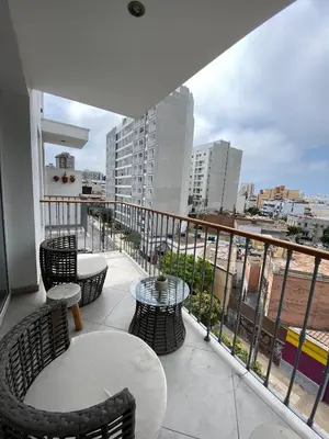 a balcony with chairs and tables and a view of a city at The Point Miraflores, Lima in Lima
