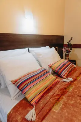 a bed with two pillows on top of it at Qosqo Wasi in Cusco