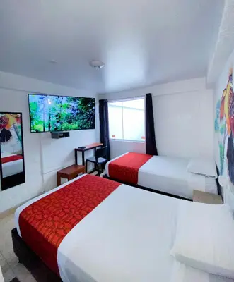 a hotel room with two beds and a flat screen tv at Magdalen House in Lima
