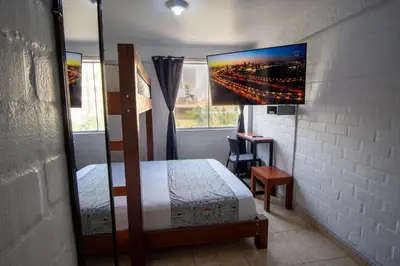 a bedroom with a bed and a desk and a window at Magdalen House in Lima