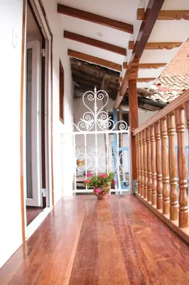 a hallway of a building with a staircase and a plant at QORI, apartamento nuevo Centro Histórico de Cusco, Cuesta San Blas 561 in Cusco