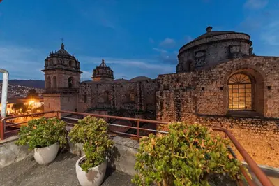 a building with two domes and potted plants on a balcony at Quechua Hotel Cusco in Cusco