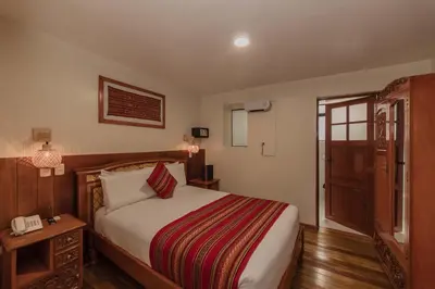 a hotel room with a bed and a telephone at Quechua Hotel Cusco in Cusco