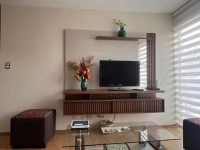 a living room with a flat screen tv on a wall at Céntrico y funcional apartamento 2 dormitorios JESÚS MARÍA LIMA in Lima