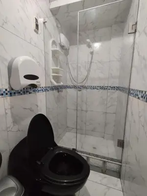 a bathroom with a black toilet and a shower at Comfortable House in Punta Hermosa