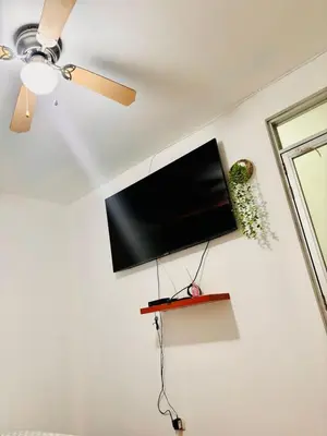 a flat screen tv hanging on a white wall at Comfortable House in Punta Hermosa