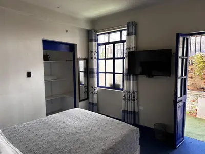 a bedroom with a bed and a flat screen tv at yuraqtampu- Pardo in Cusco